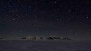 time-lapse of the winter night sky over Rothera Point shown as a distant range of mountains in the lowest third of the image and bright stars above